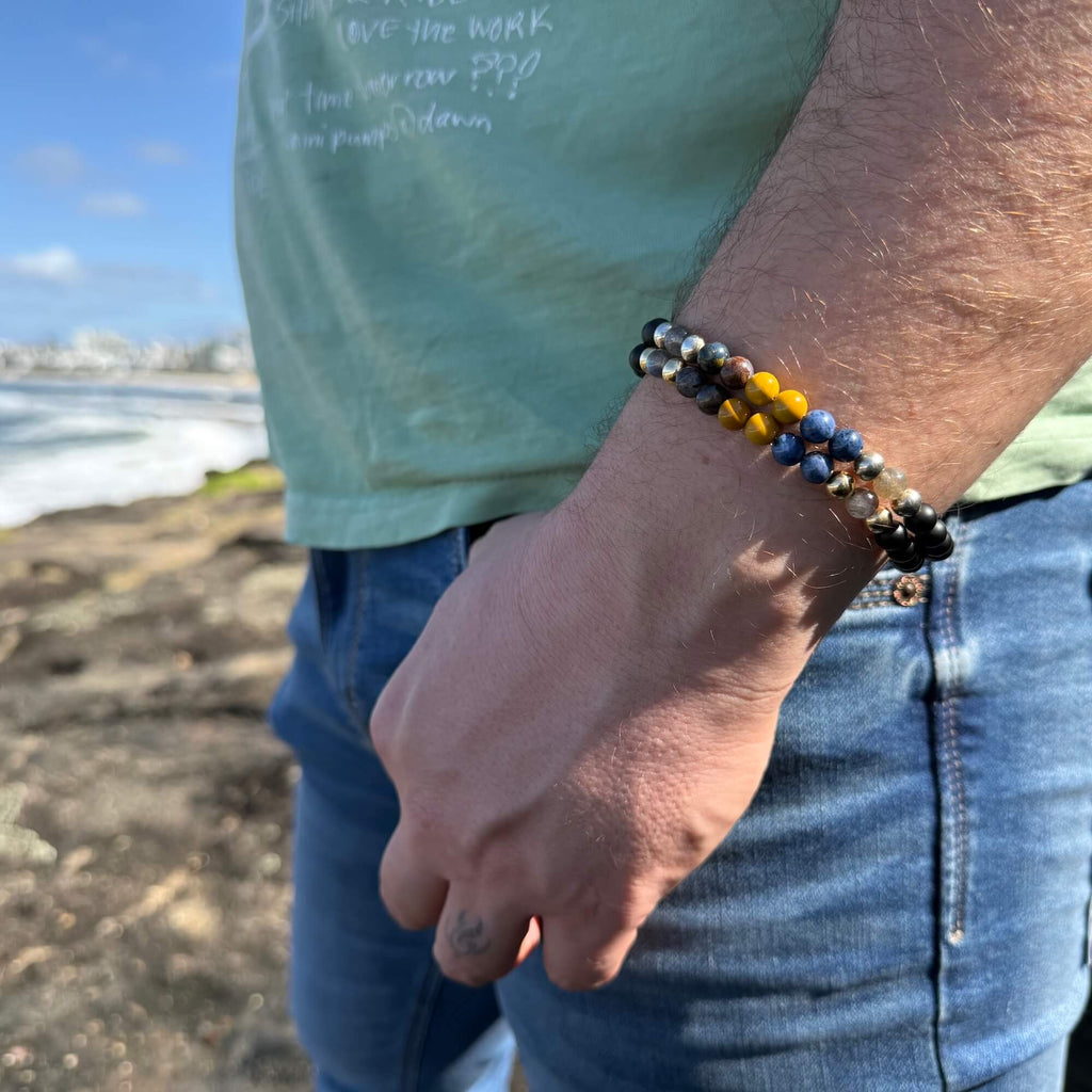Man in jeans at the coast wearing the Phoenix Rising bracelet