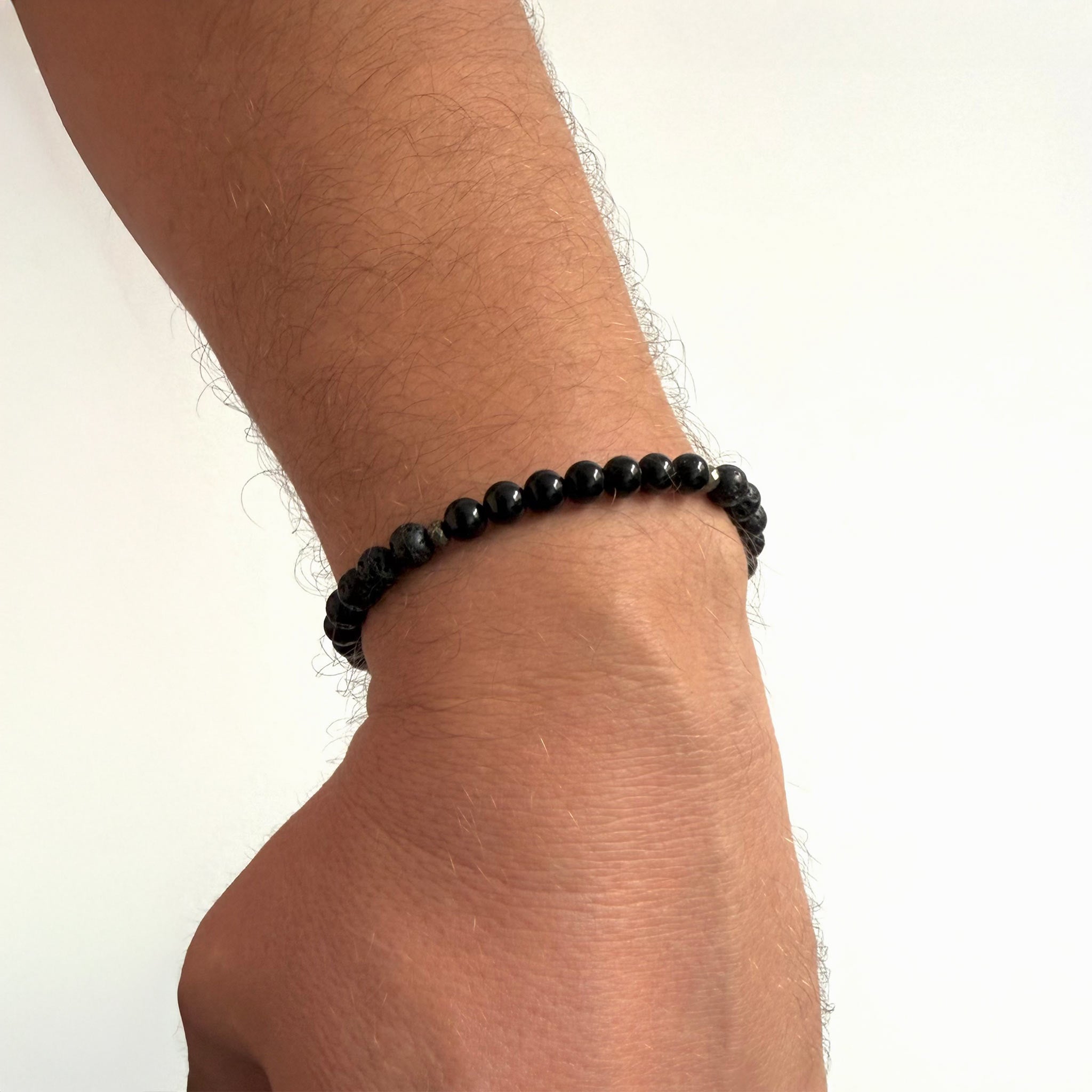 Men’s Inner Strength bracelet featuring black tourmaline and lava stone beads worn on the wrist