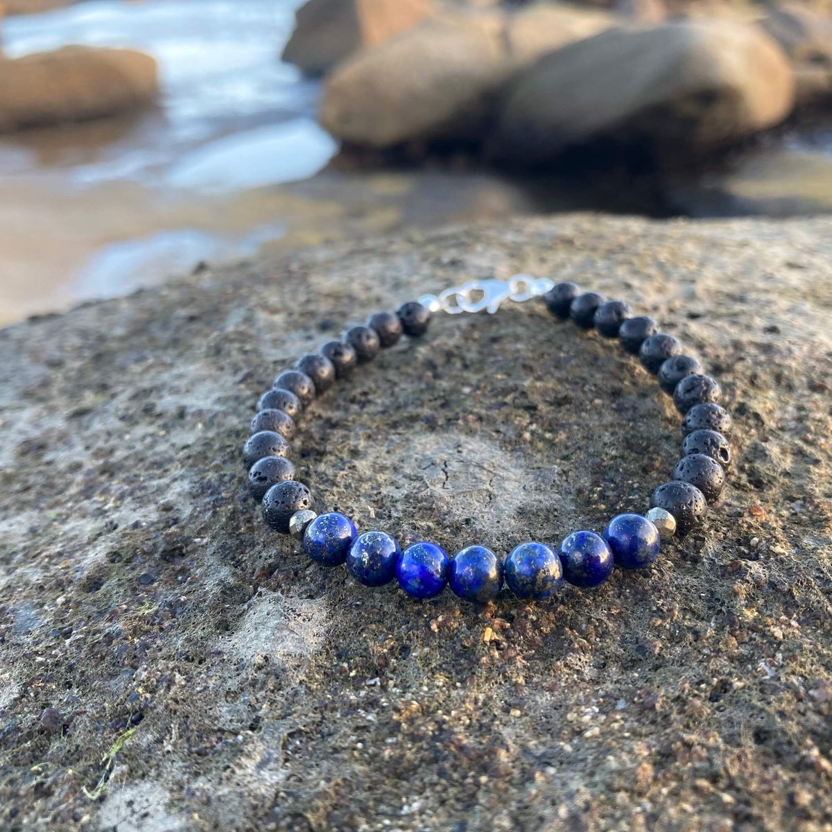 Close-up of the Self-Awareness bracelet's blue lapis lazuli beads on stone