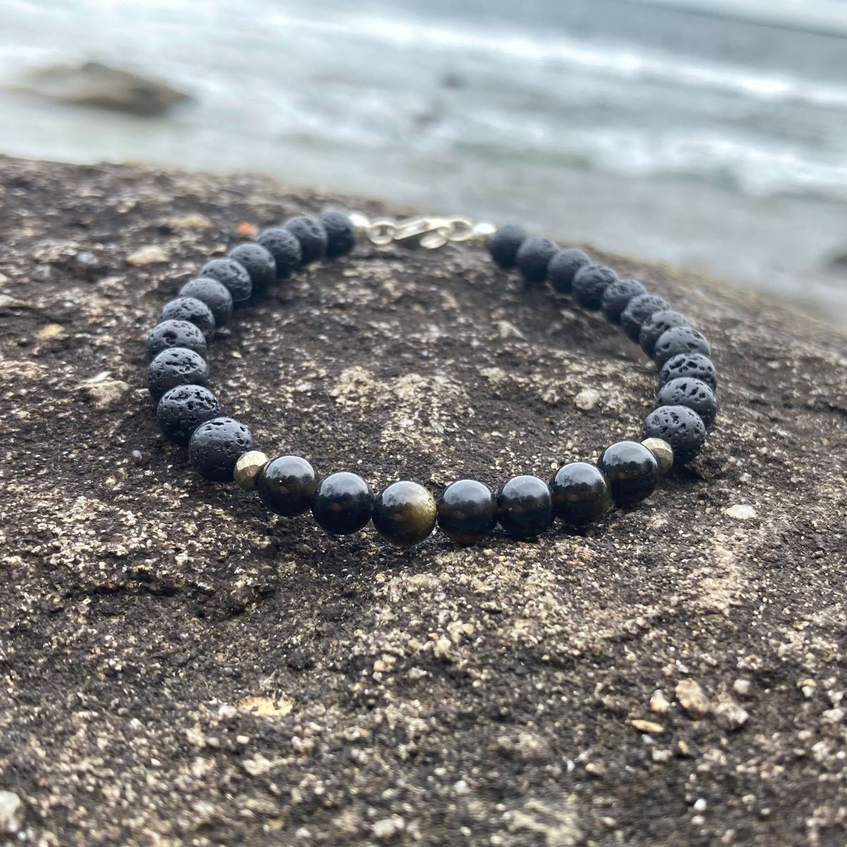 Facing Fears bracelet on a rock ledge by the water