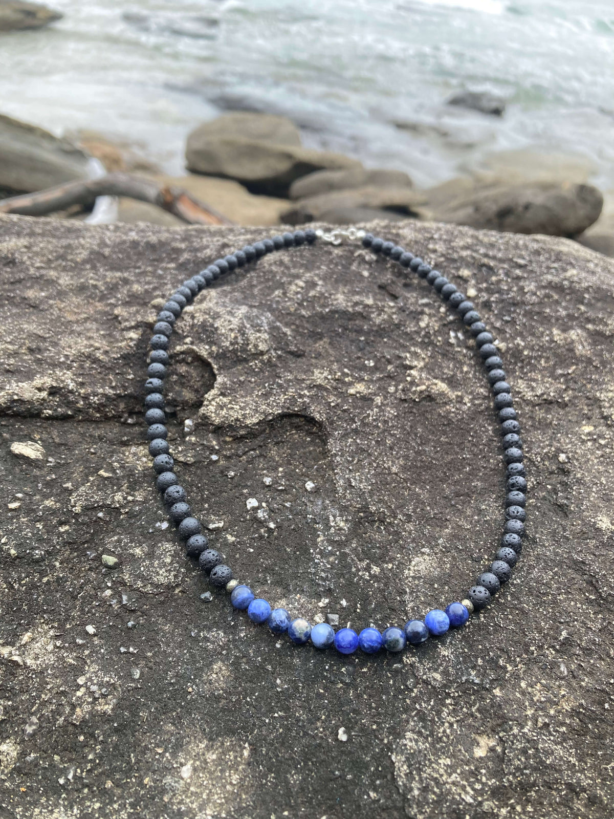 Focus necklace on rock, seen from further back