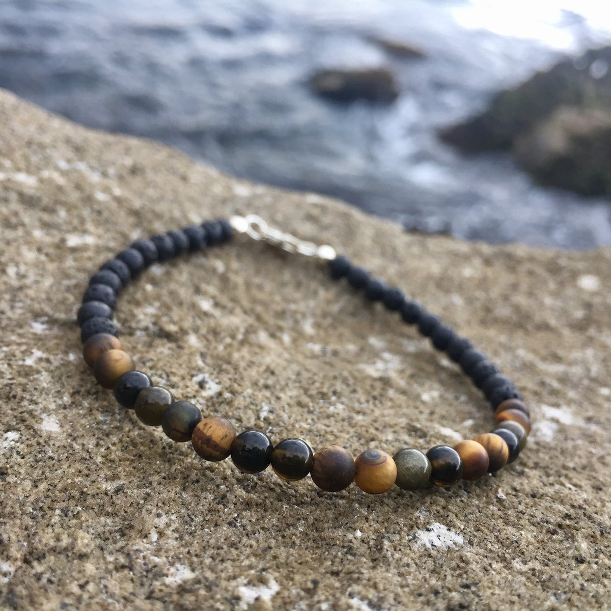 Fortitude bracelet on coastal rock with the sea behind