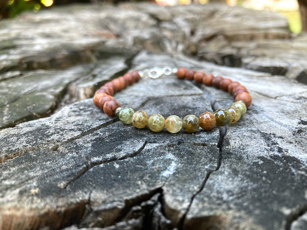 Growth garnet and wood bracelet on a tree stump in daylight