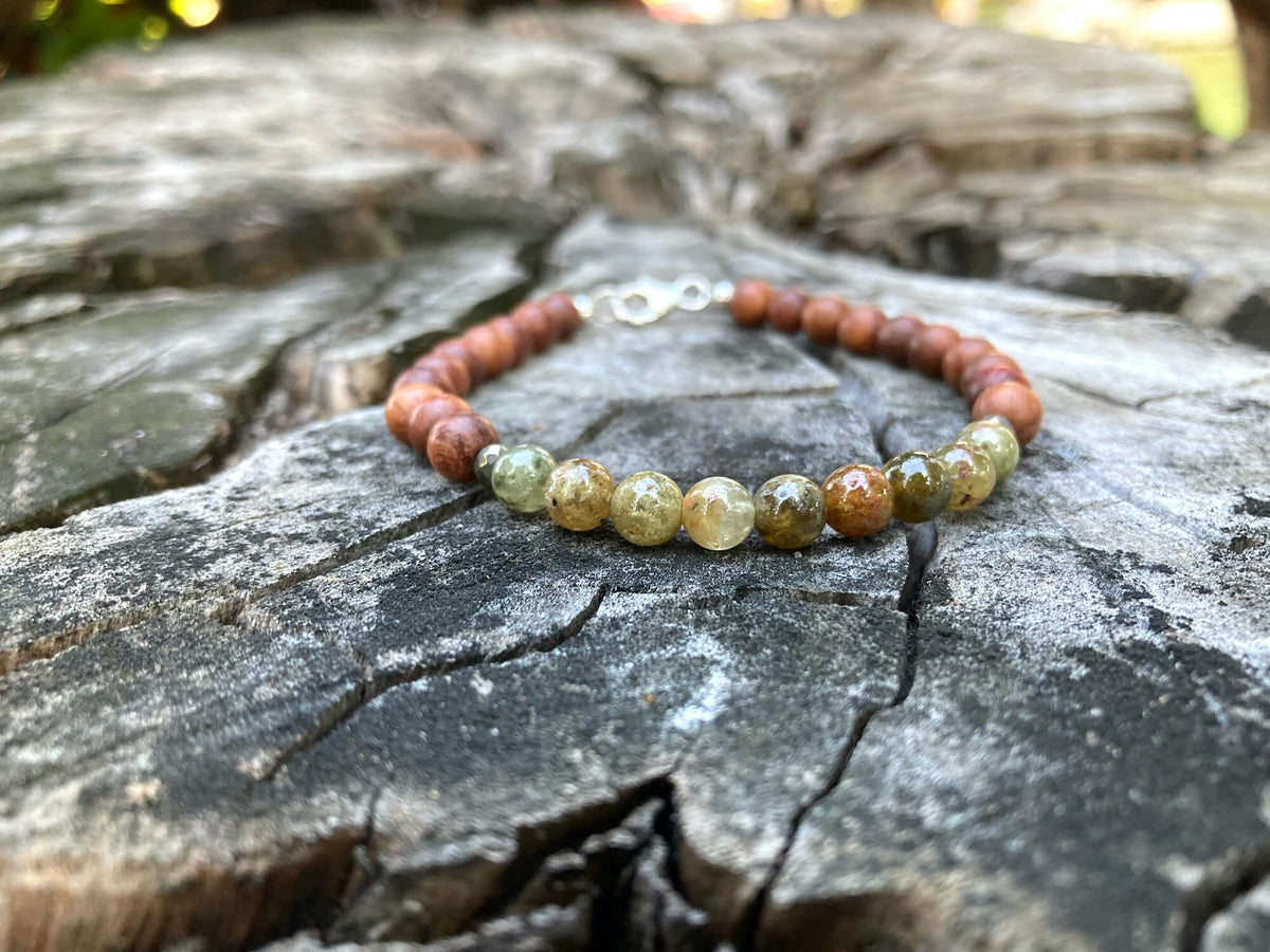 Growth garnet and wood bracelet on a tree stump in daylight
