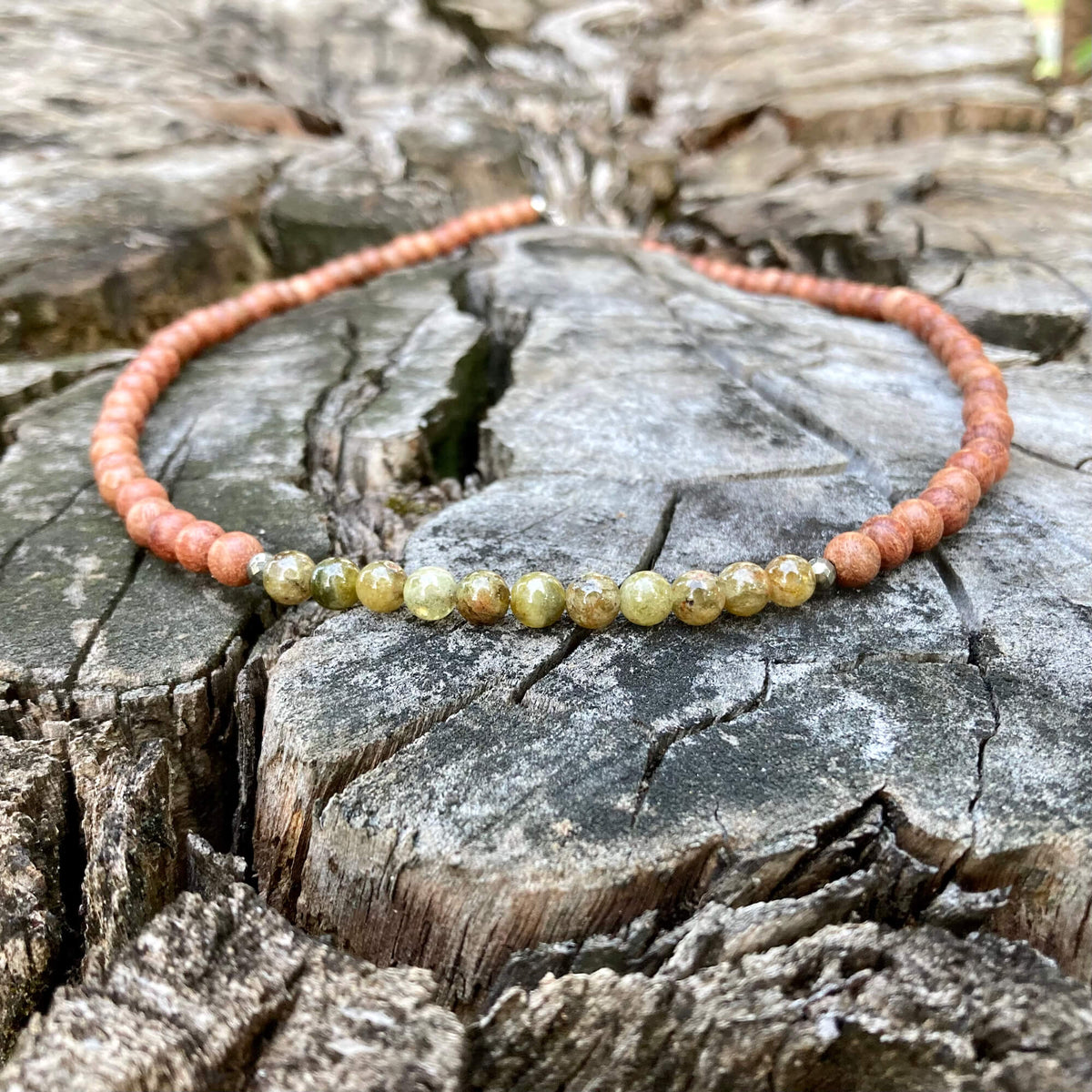 Growth men's necklace: green garnet with natural wood beads, laid on a weathered stump