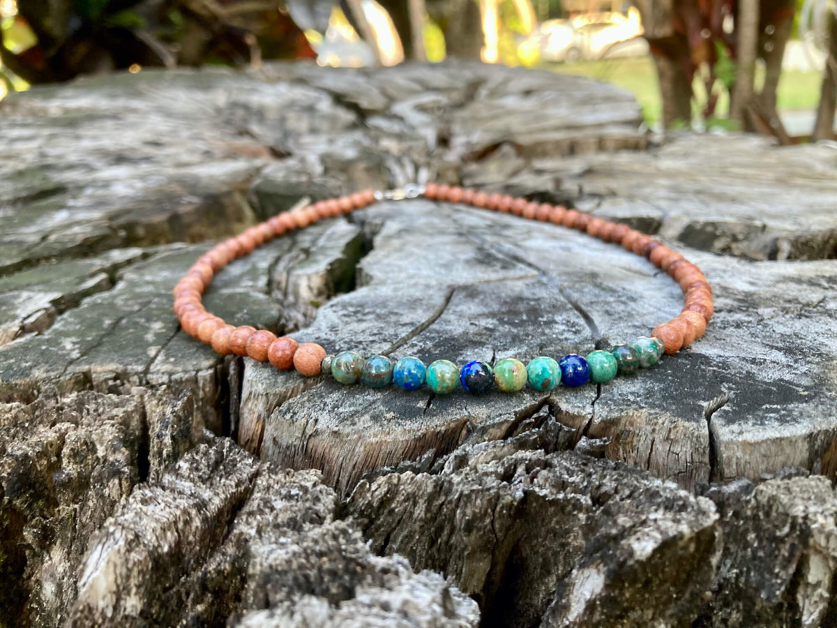 Inner Wisdom necklace on a stump, seen from further back