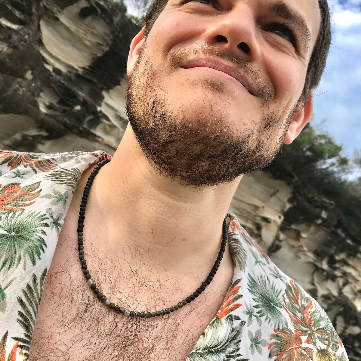 Man looking up at the sky, wearing the Drive necklace