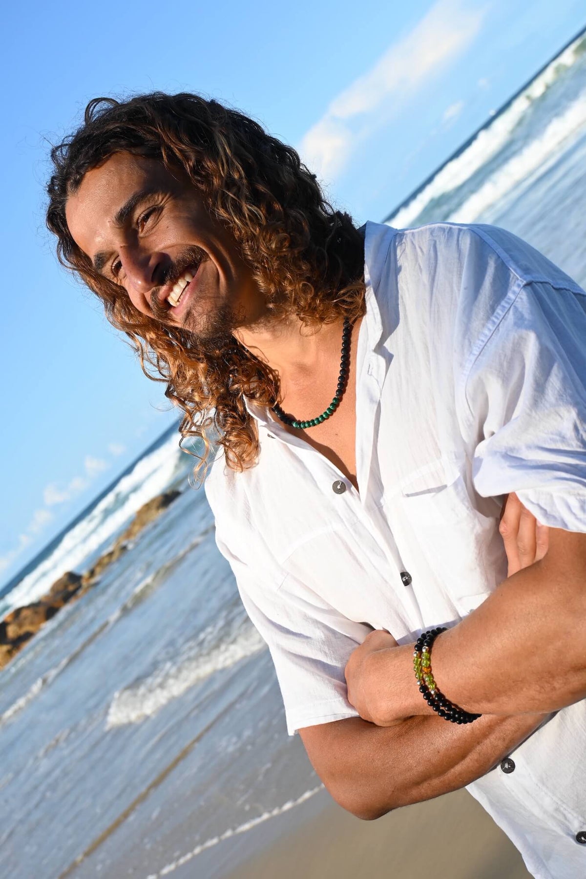 Man in a white shirt at the beach wearing The Liberator bracelet