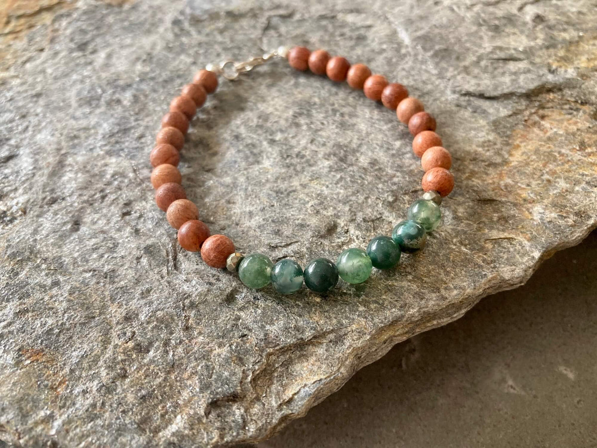 New Beginnings bracelet on a rock slab, sterling silver clasp at the top
