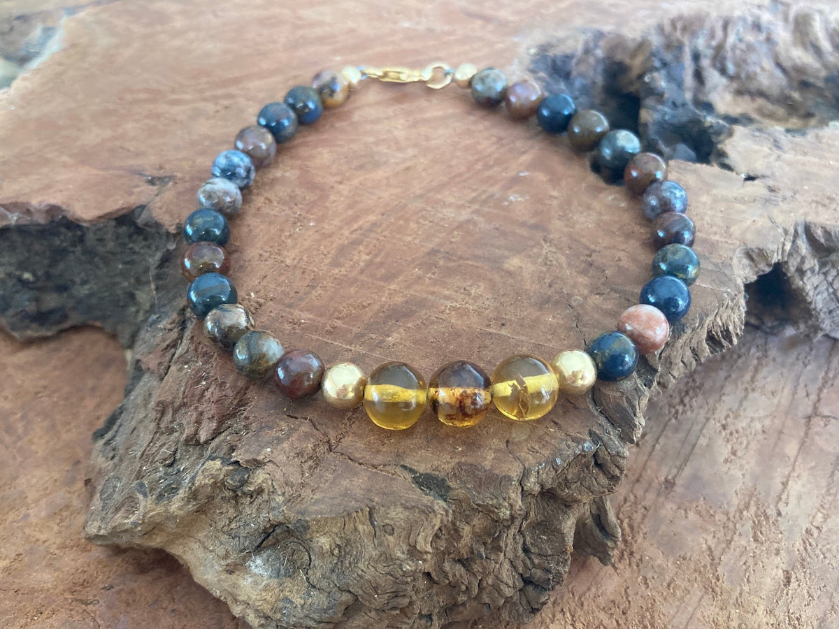 Pietersite and amber men's bracelet on weathered wood, gold-fill clasp at the back