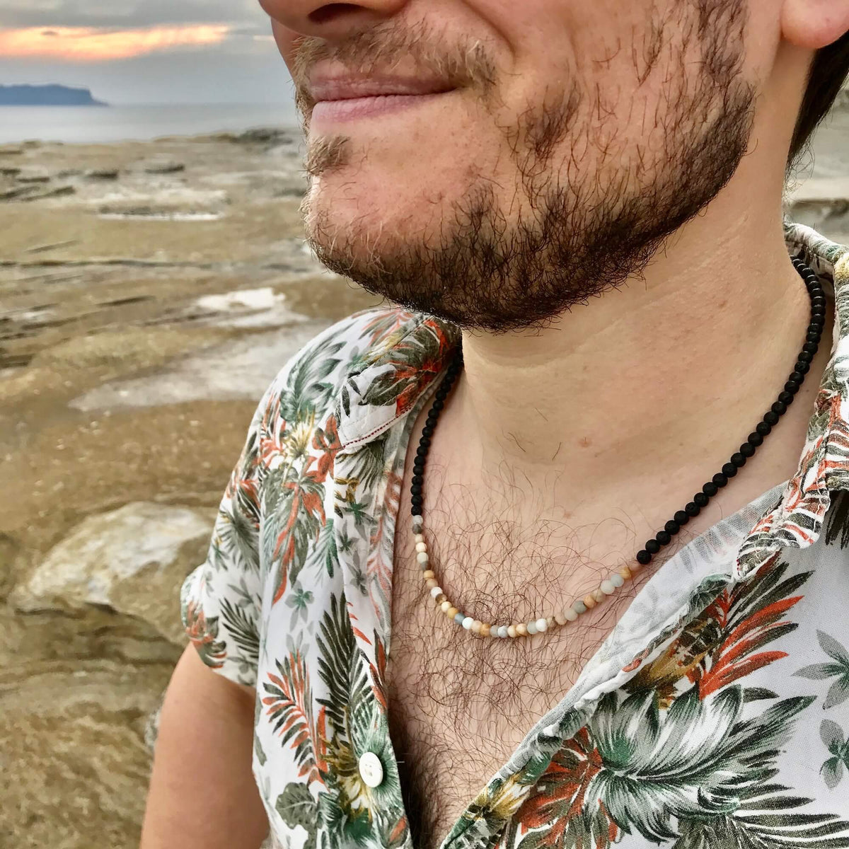 Smiling man in a floral shirt wearing the Vitality necklace