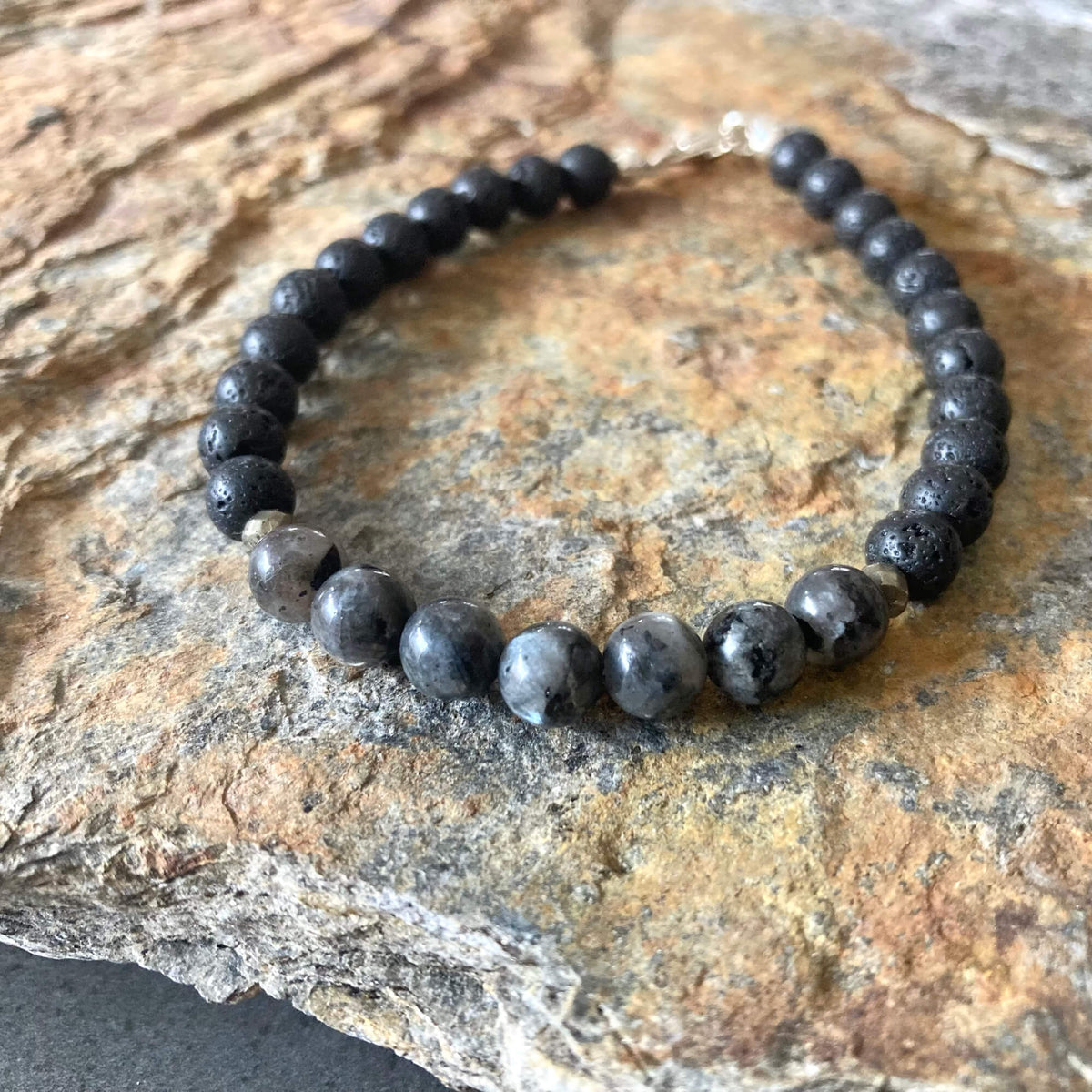 Transformation bracelet from above on sandstone, sterling silver clasp at the top