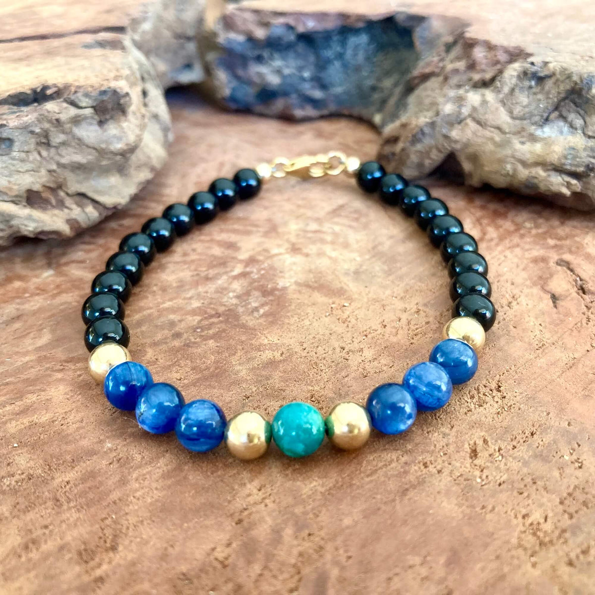 Turquoise chrysocolla centre bead framed by blue kyanite and gold-fill beads on The Alchemist bracelet