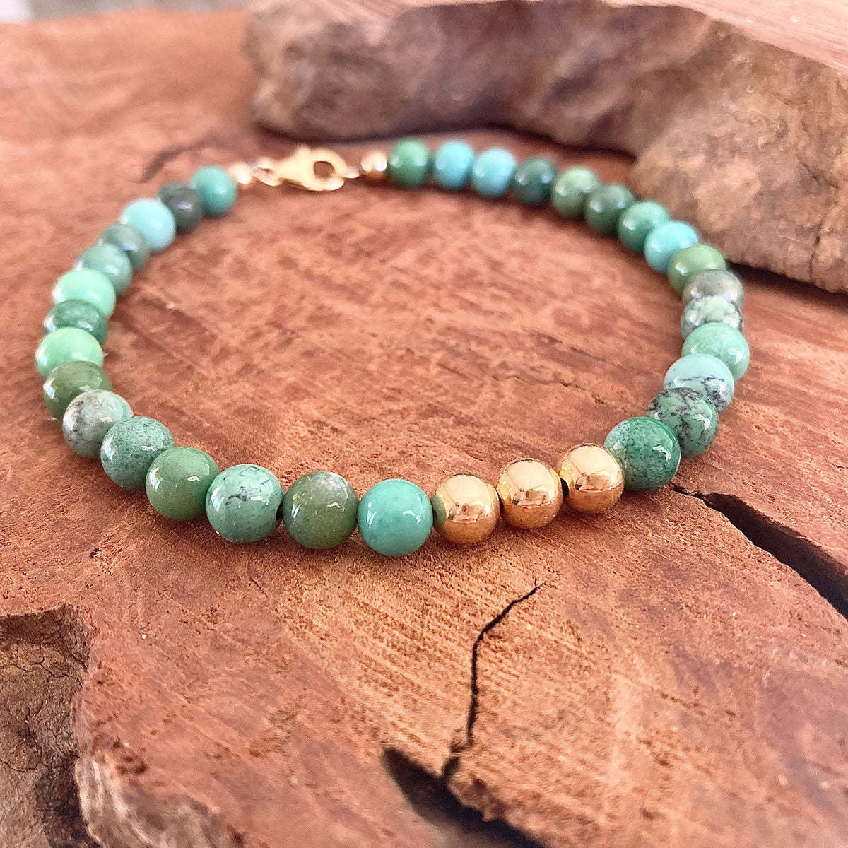 The Wayfinder men's bracelet: green Australian chrysoprase with 14k gold-fill beads, on red sandstone