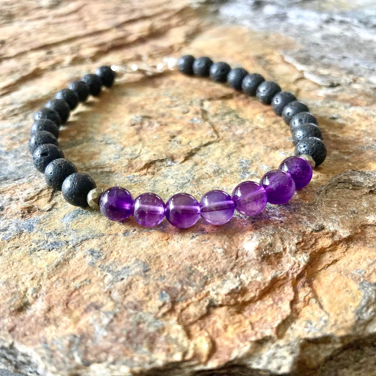 Zen bracelet on orange-veined sandstone, amethyst beads at the front