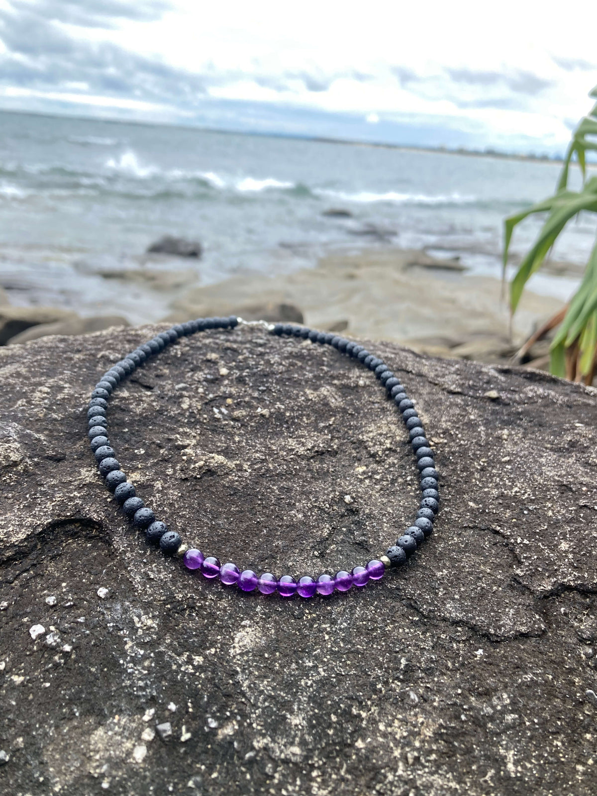 Zen necklace on rock with the sea behind
